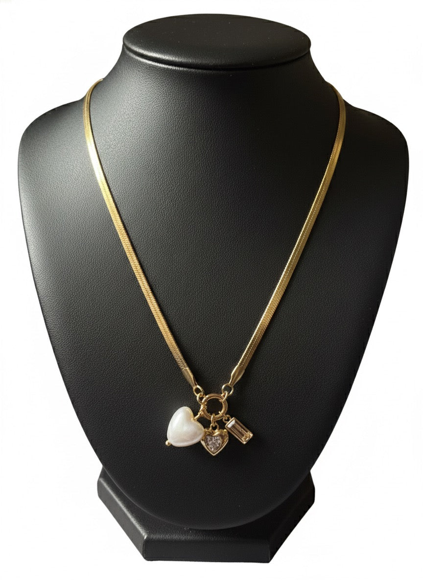 Gold-tone necklace featuring three charms.