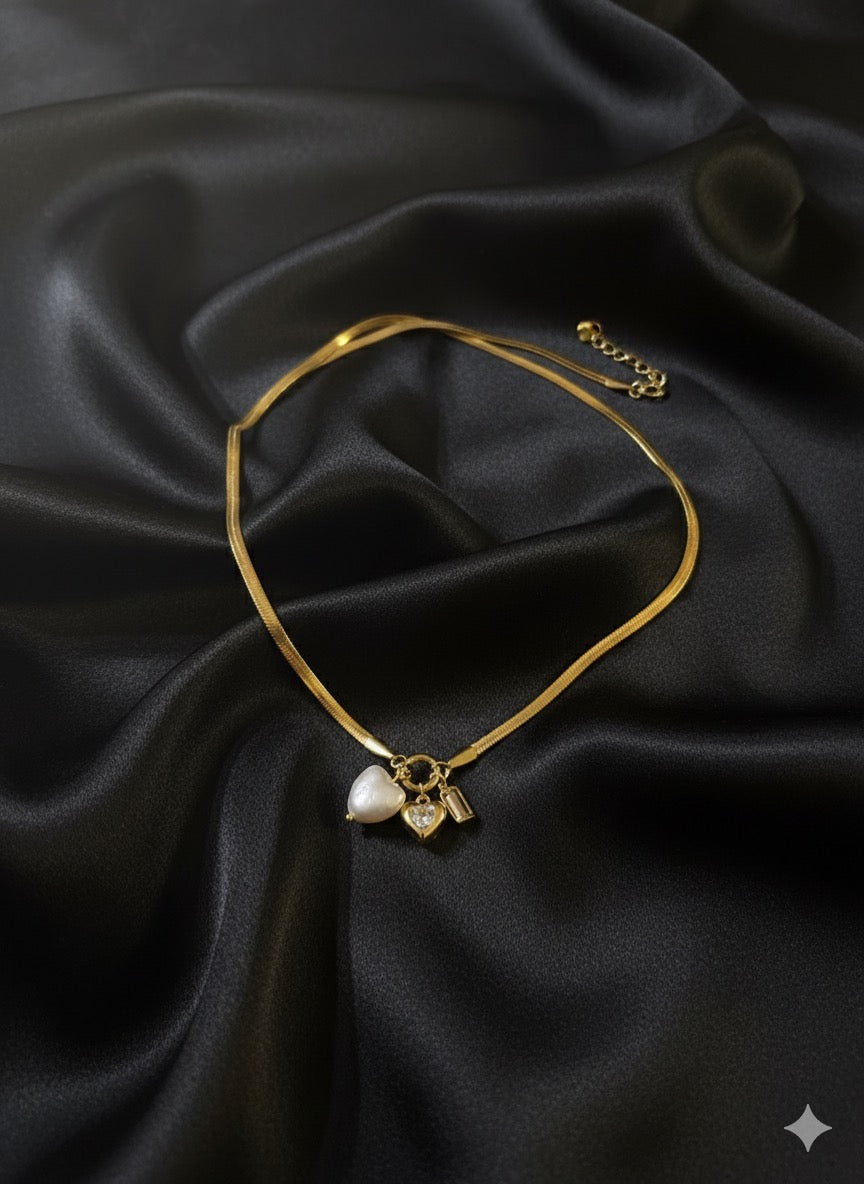 Gold-tone necklace featuring three charms.
