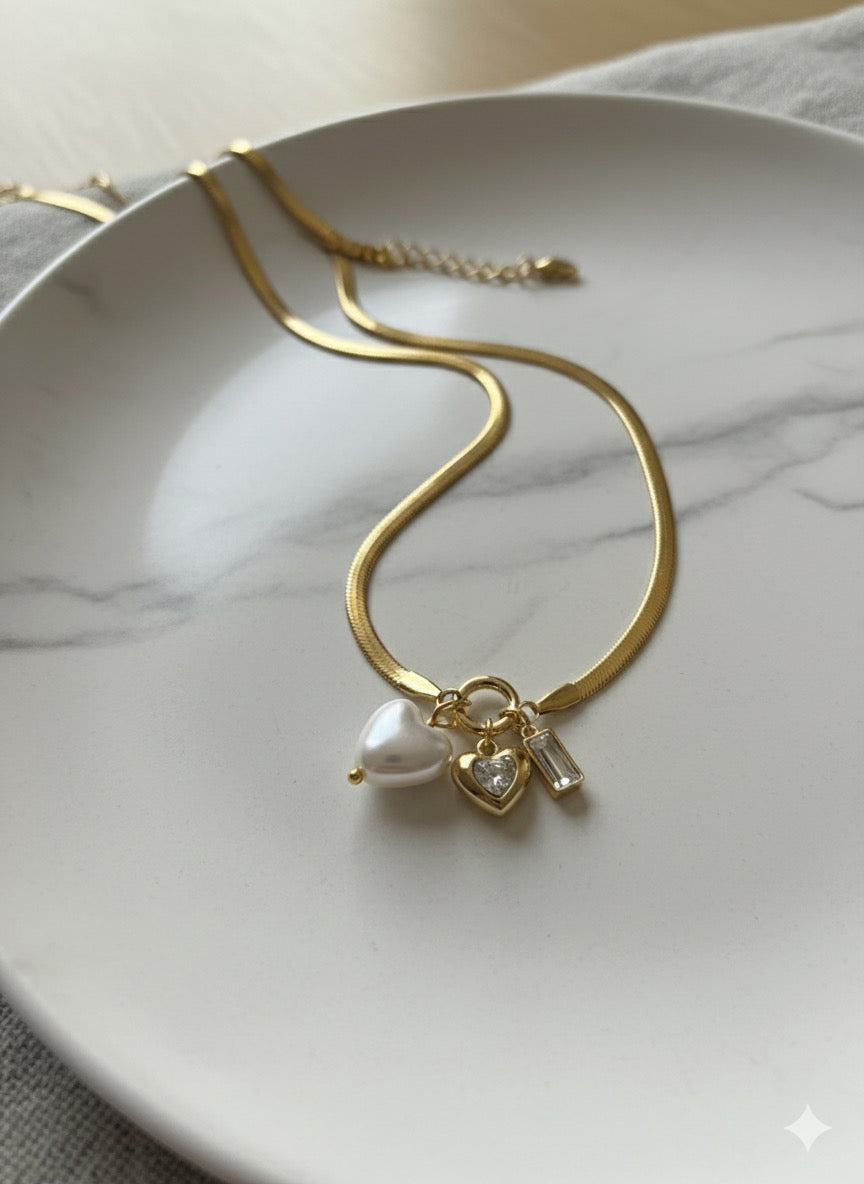 Gold-tone necklace featuring three charms.